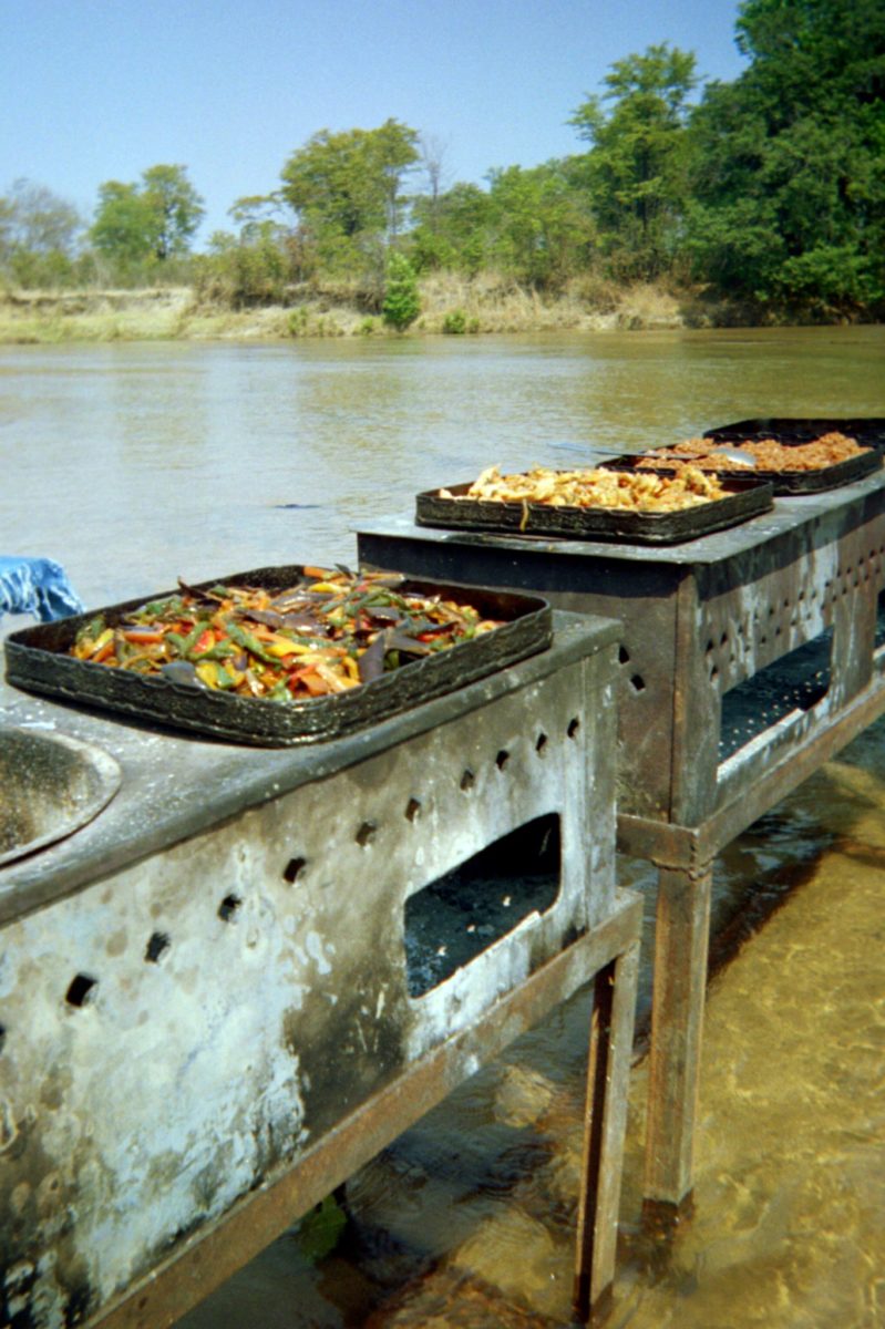 mobile stoves in the river cooking various meats and peppers in zambia's south luangwa national park