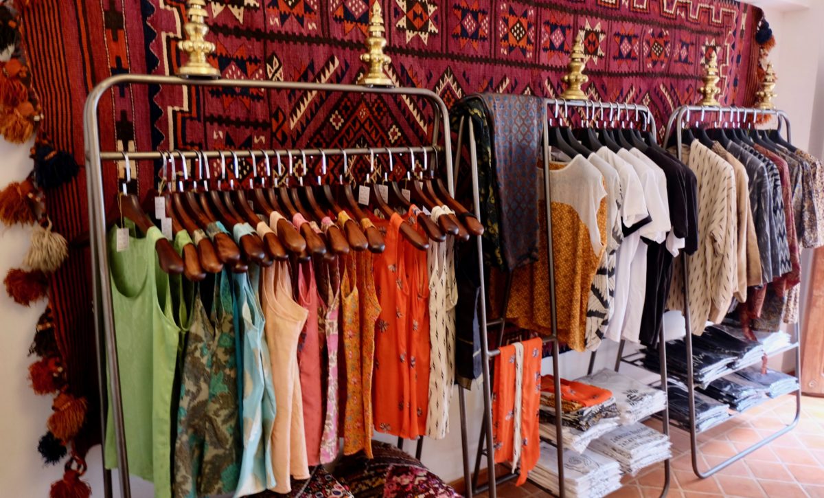 a rack of colorful shirts at Of Silk and Salt's boutique