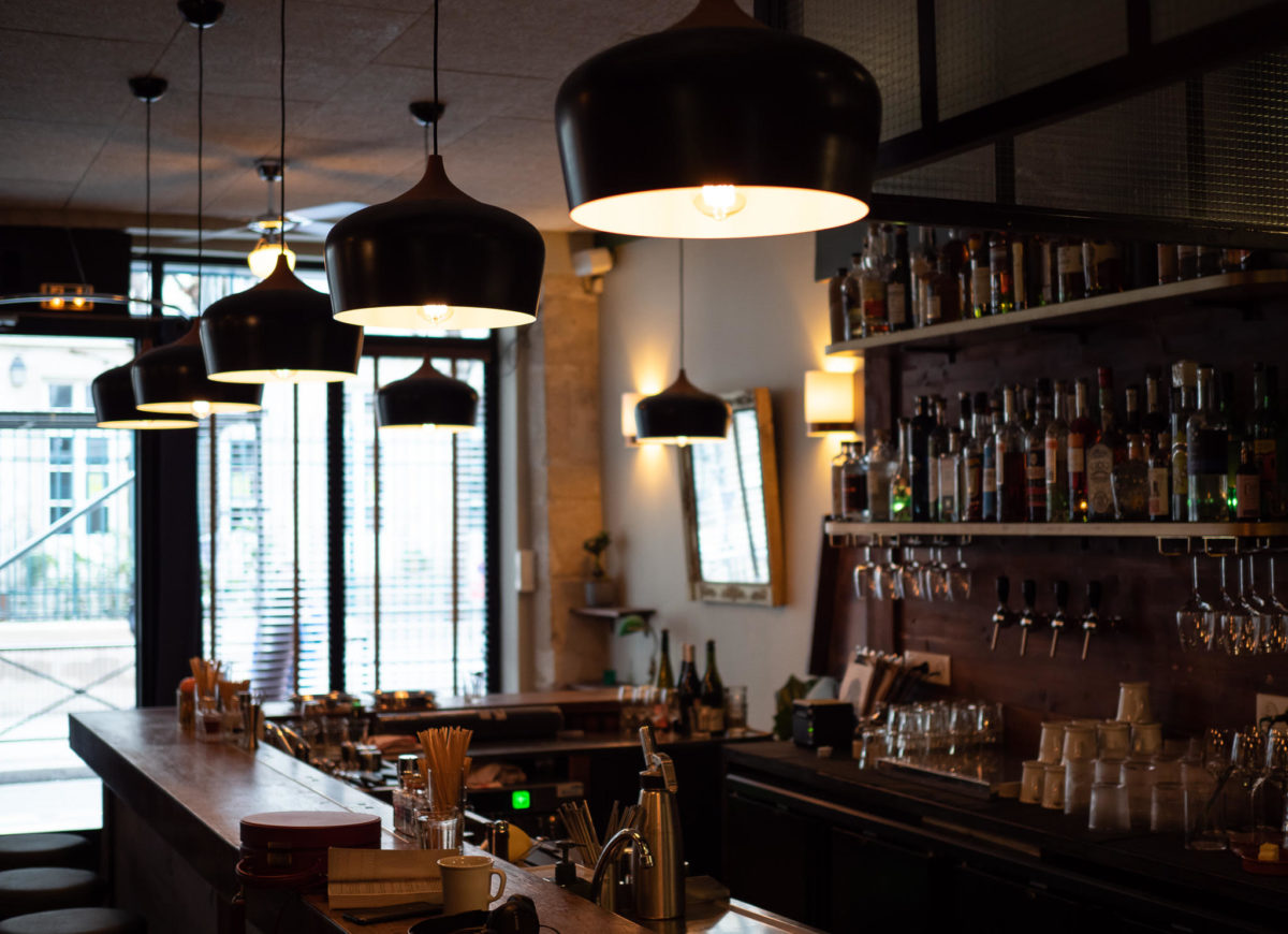 lights hanging over a dimly-lit bar counter