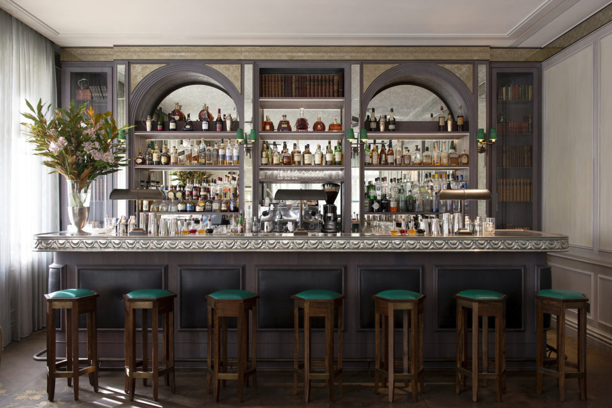 an upscale mirrored bar with green barstools