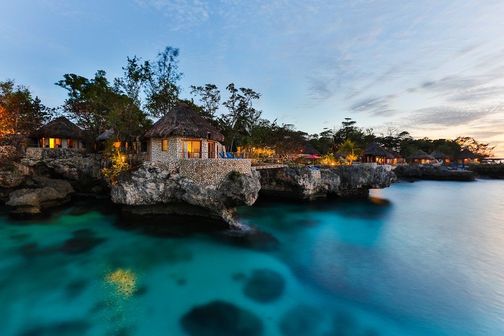 several villas on a rocky ocean cliff at dusk