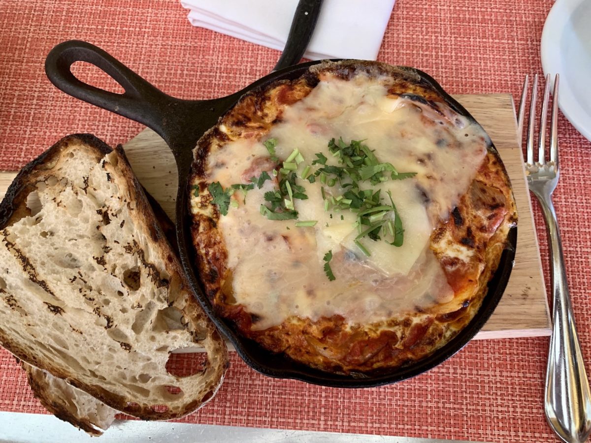 bread and skillet of shakshuka with cheese