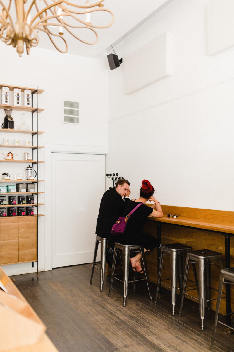 two people sitting at a counter in a coffee shop