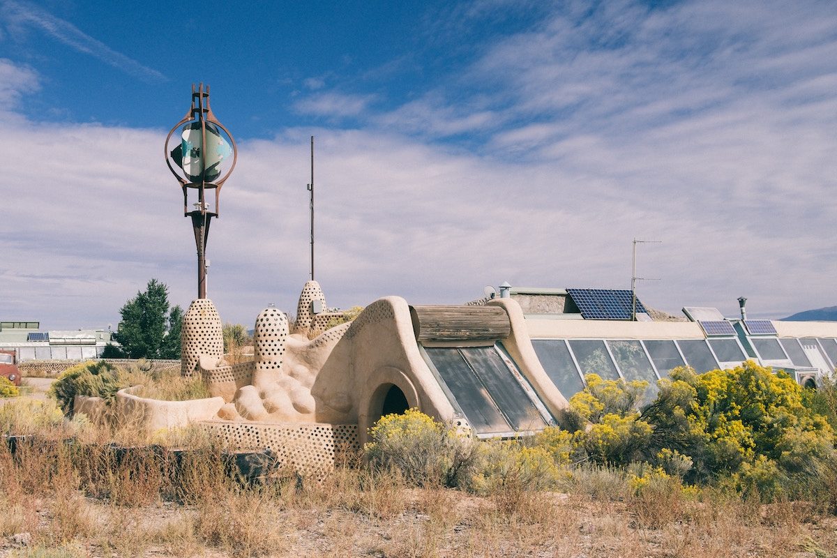 an adobe-style structure built into the ground with solar panels