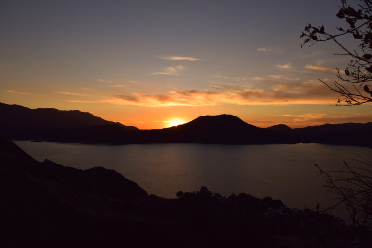 sunset falling behind mountains on a lake