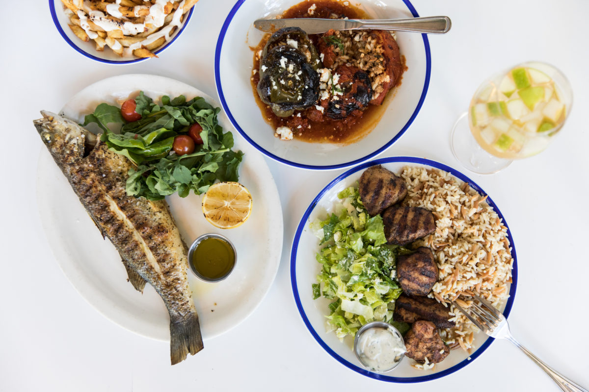 a table full of Mediterranean food, including fish and soup