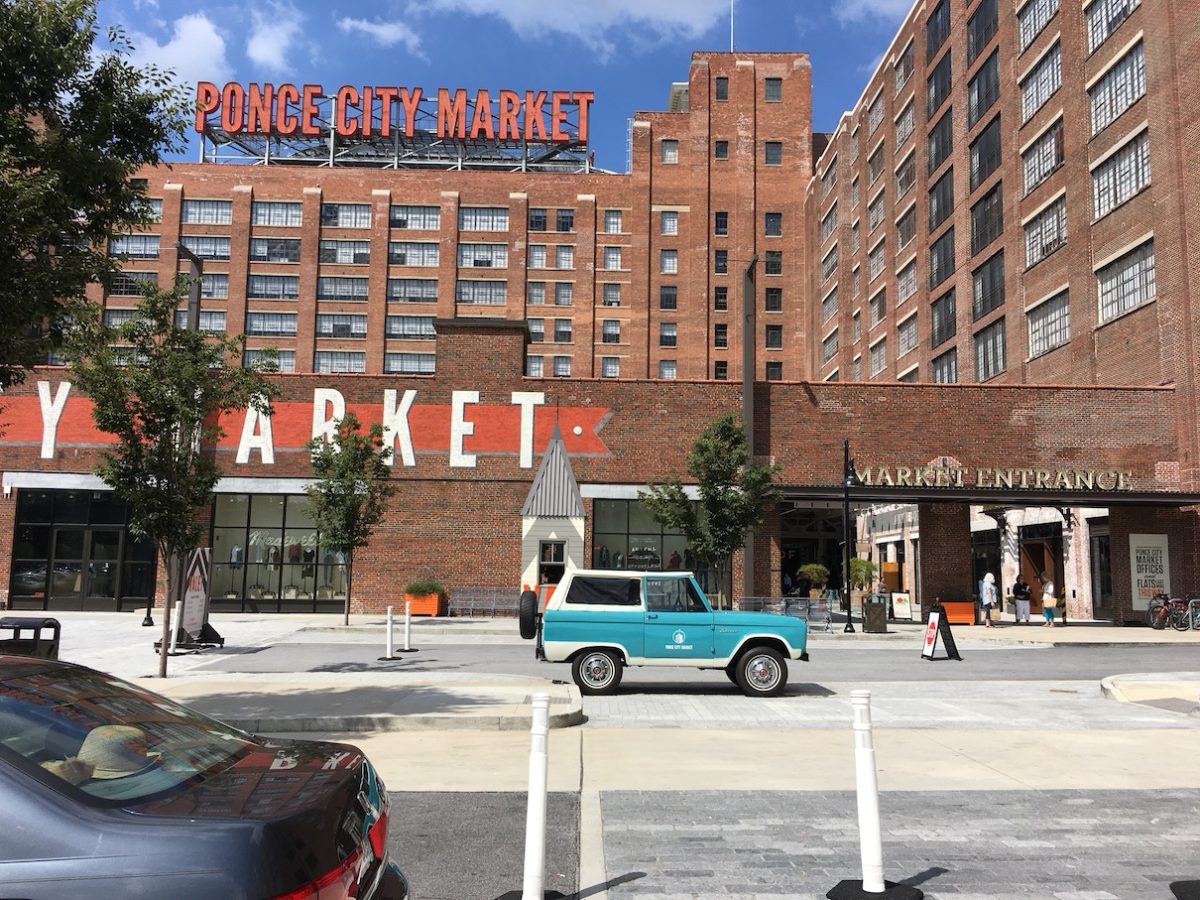 a multi-story brick building with a sign reading Ponce City Market on a sunny day