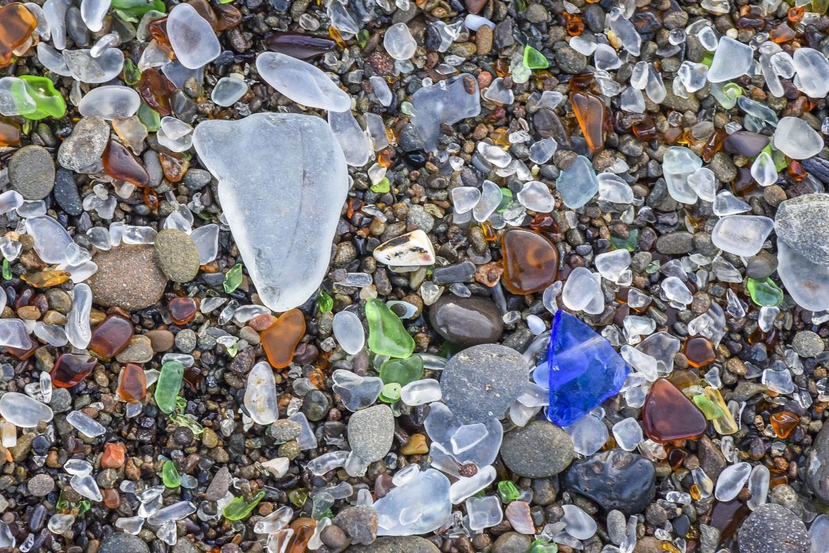 a close up of colorful stones in sand