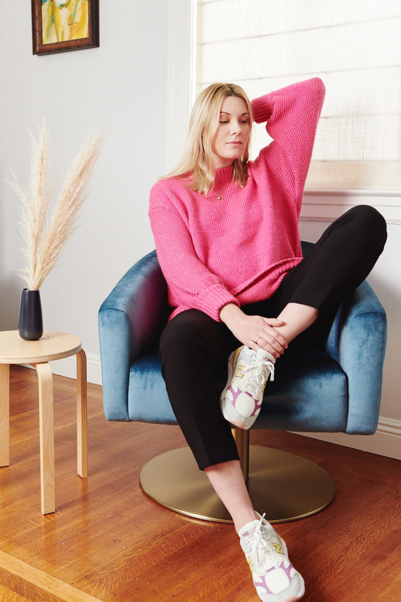 woman sitting on a chair running her hands through her hair