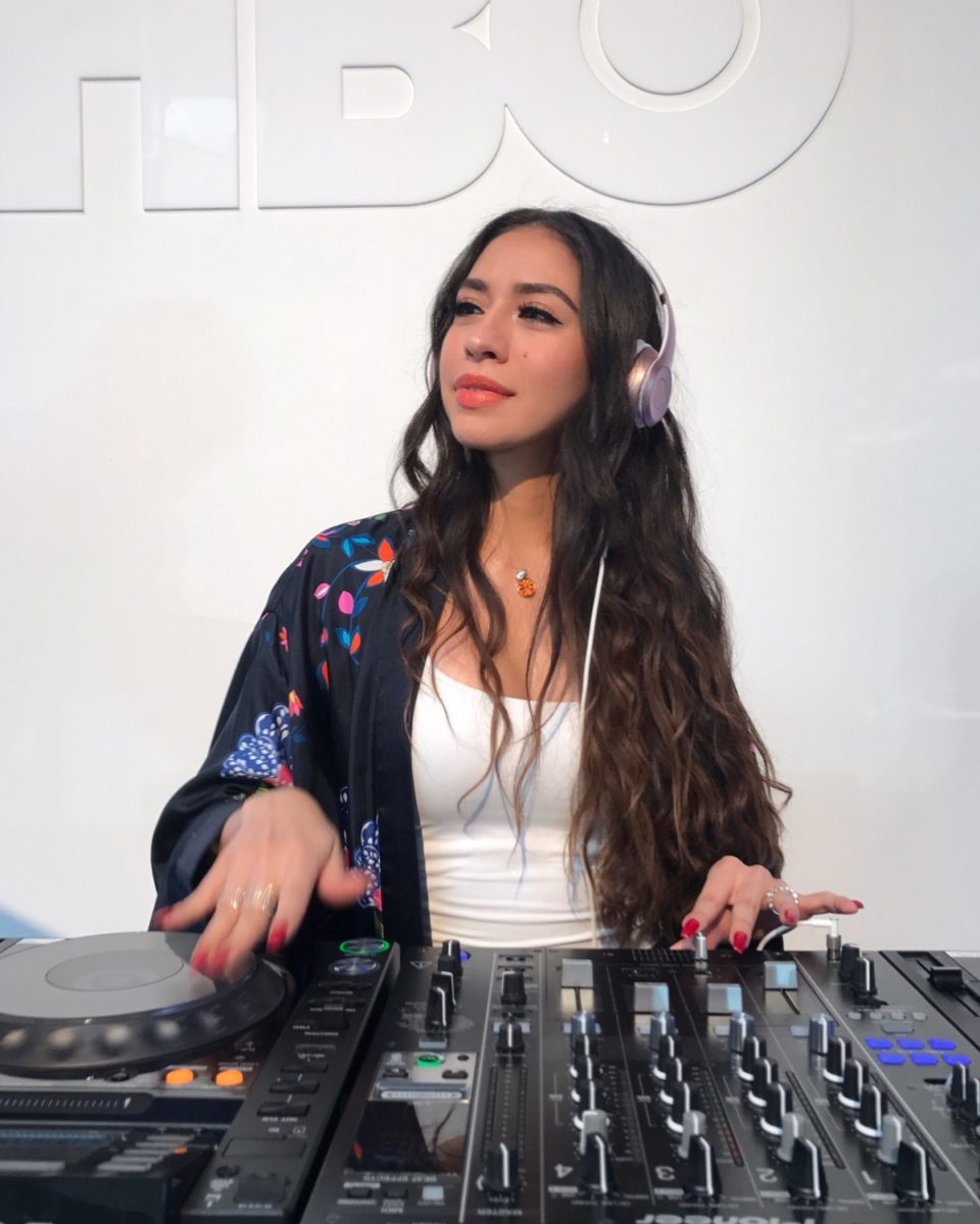 a woman at a dj booth in a white room