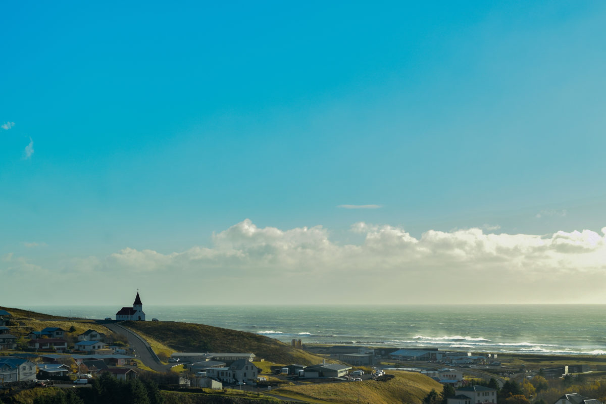 a church on a hill by the sea on a sunny day