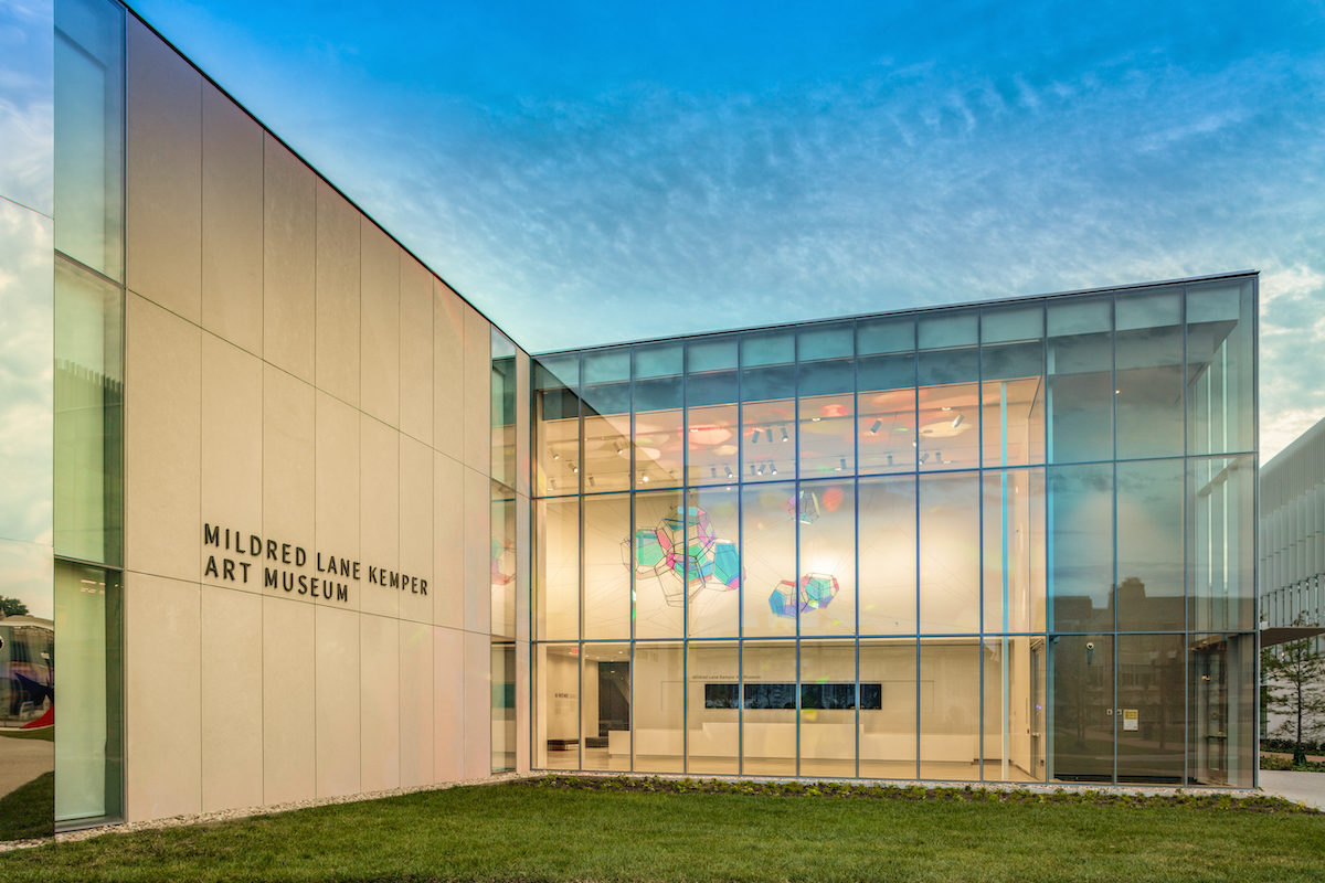 museum building with glass walls lit up at dusk