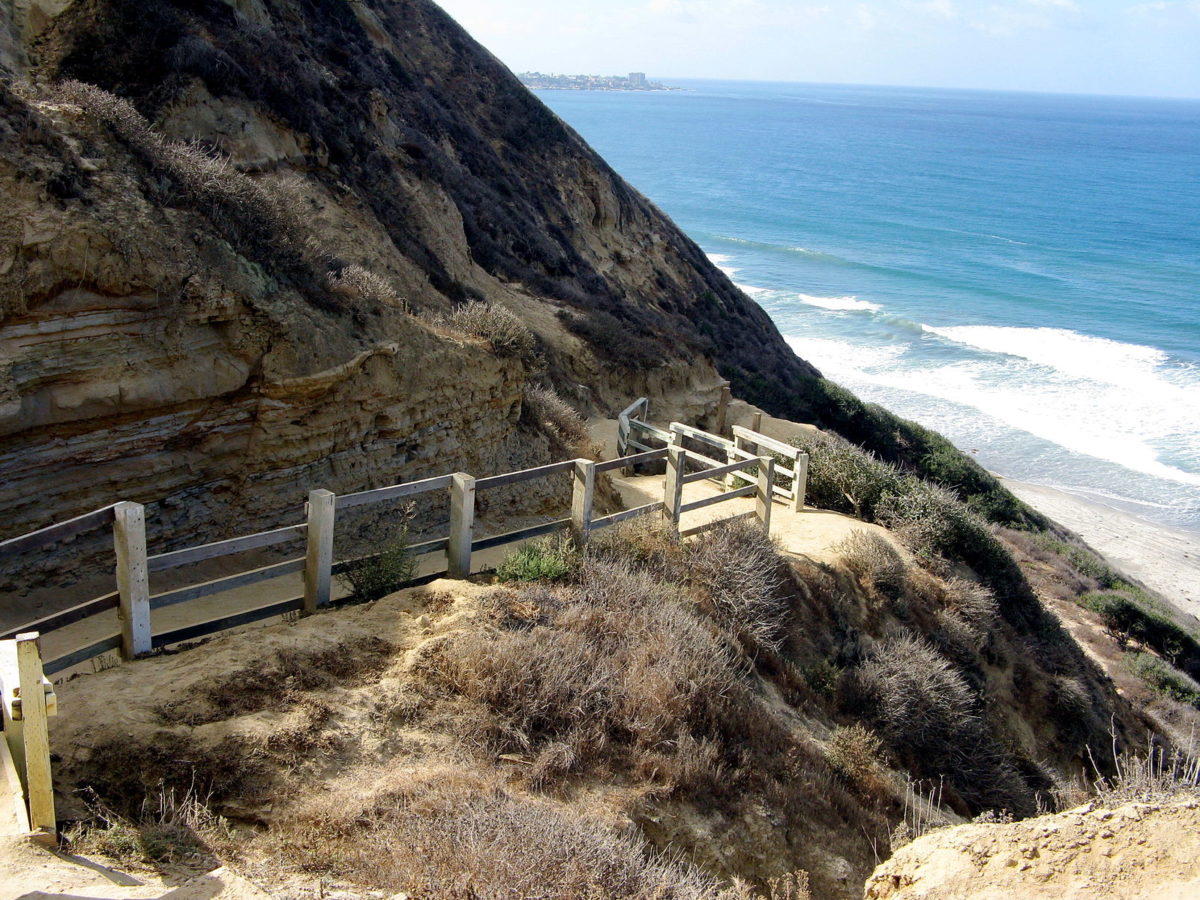 hiking trail on the side of a cliff near the beach