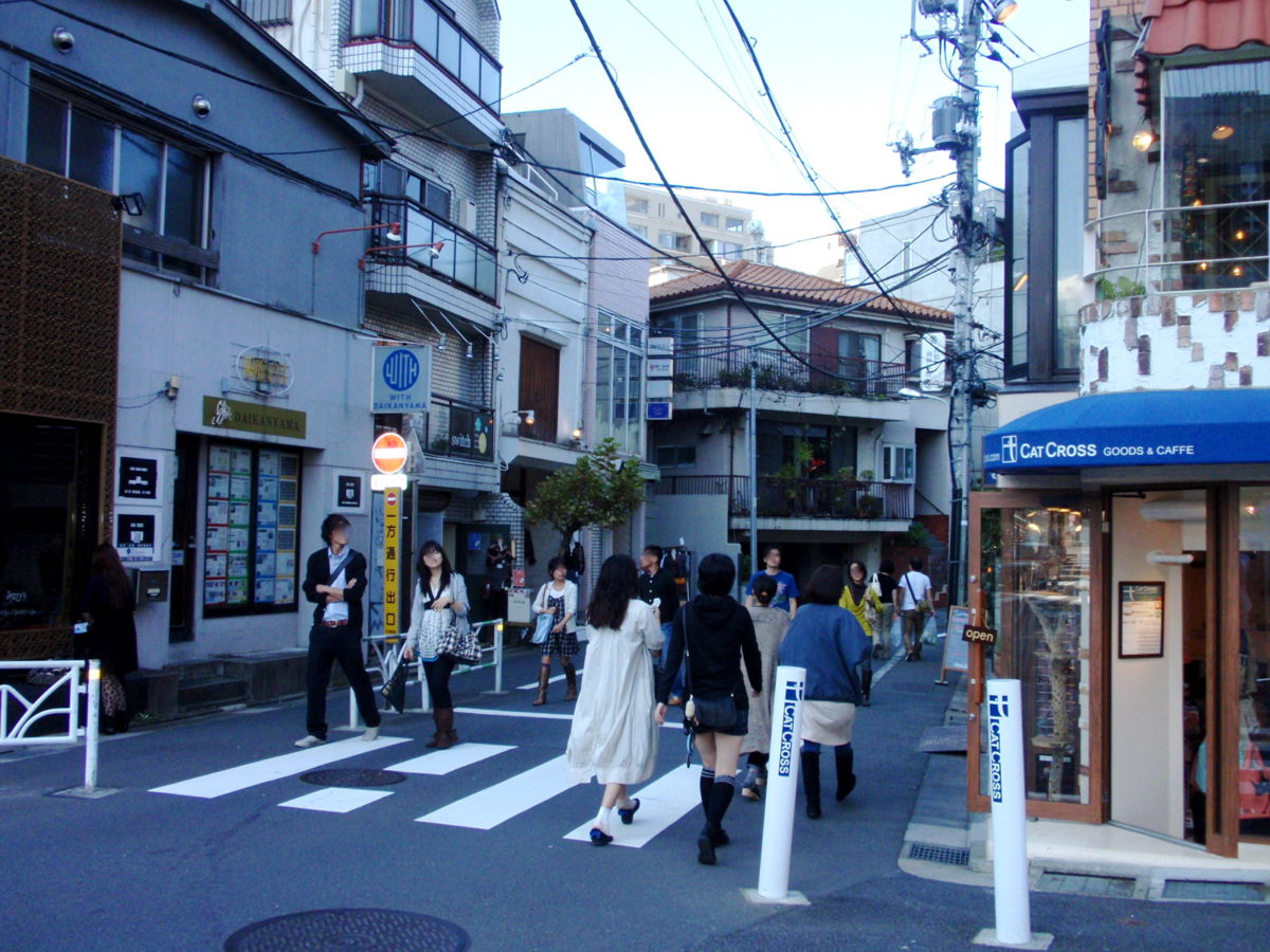 young people walking down a narrow street at dusk