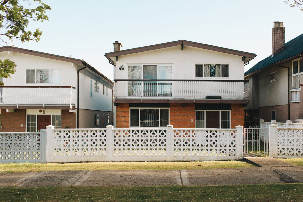 a house with a fence on a sunny day