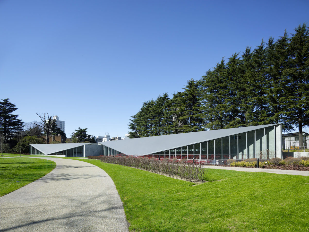 a building with a triangular roof angled toward the ground on a sunny day