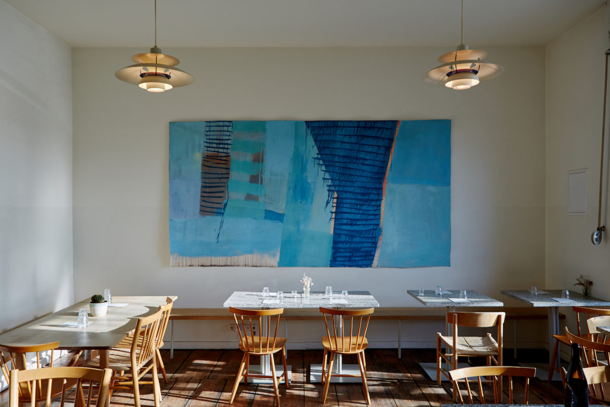 chairs, tables, and booths inside a brightly-lit restaurant