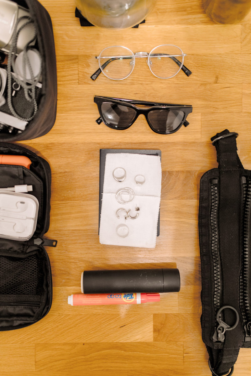 eyeglasses, sunglasses, earrings, rings, and a lint roller on a table