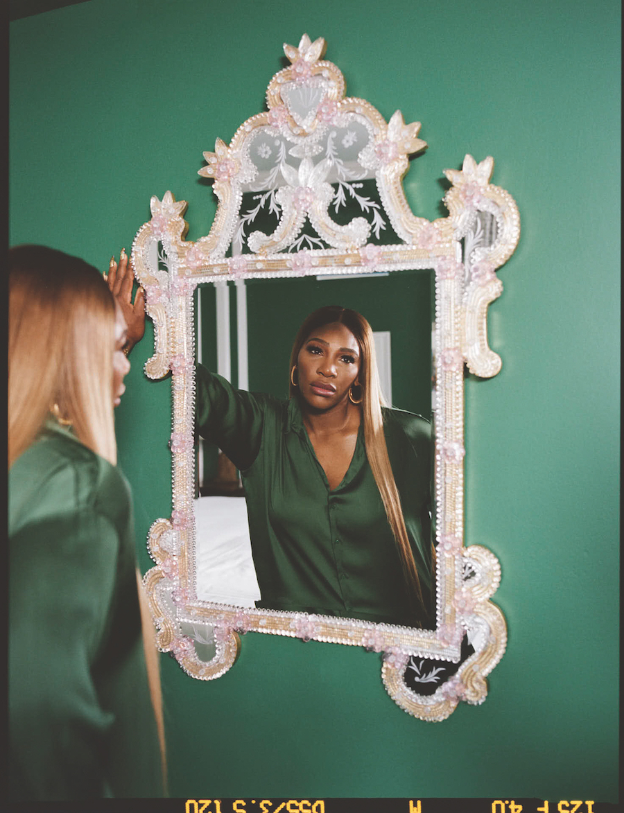 a woman in silk pajamas gazing at her reflection ini the mirror