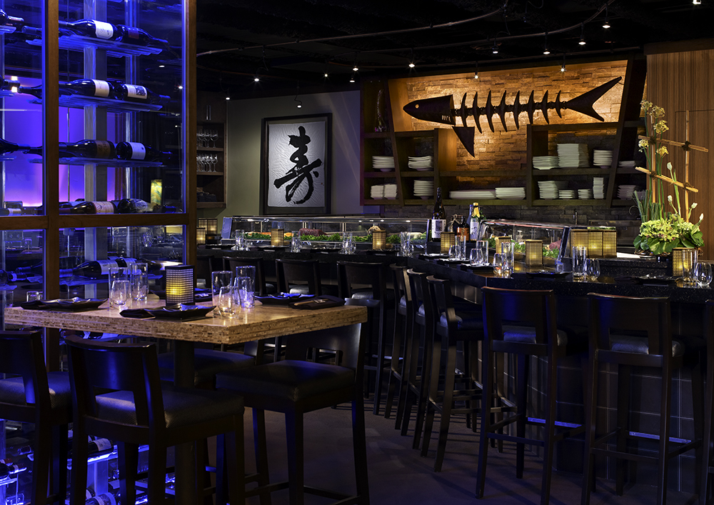 high tables, chairs, and a bar at a dimly lit Japanese restaurant