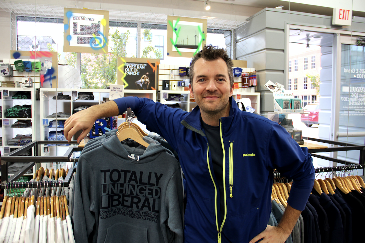 Mike Draper in his store next to racks of screenprinted shirts