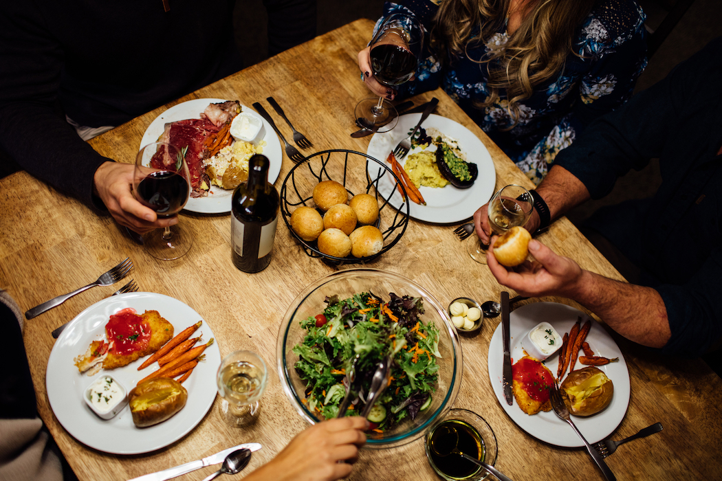 people gathered around a table full of food