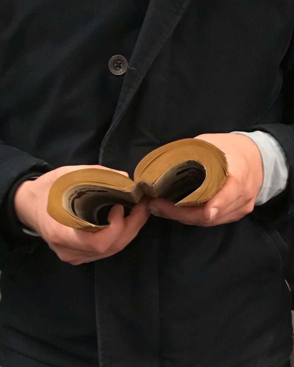 hands bending a paperback book