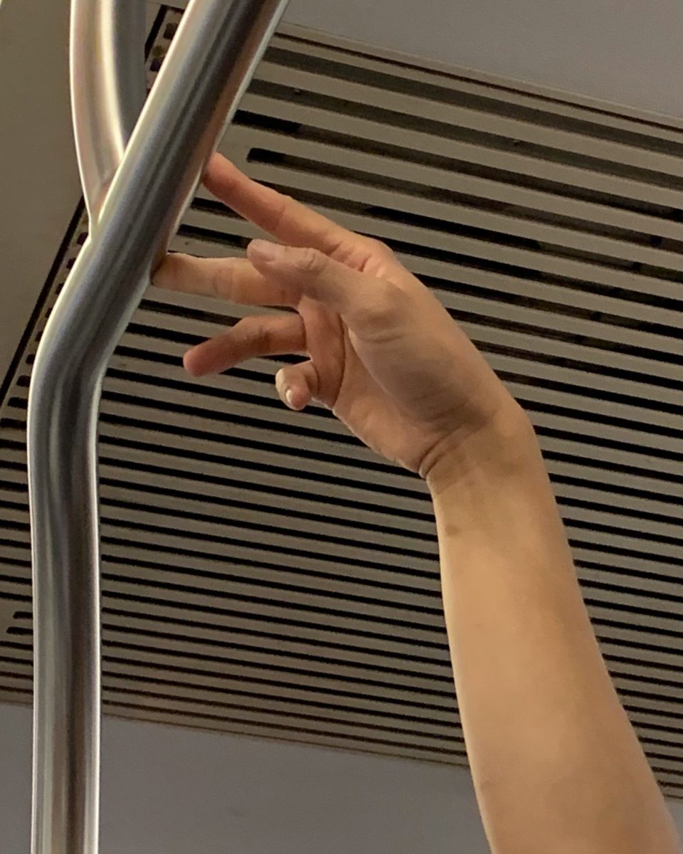 hand pressed oddly against a subway rail