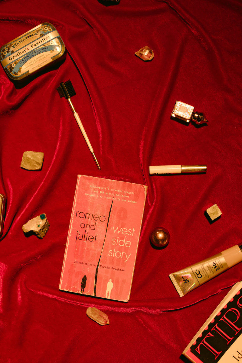 a script, throat lozenges, and makeup lying on a velvet cloth