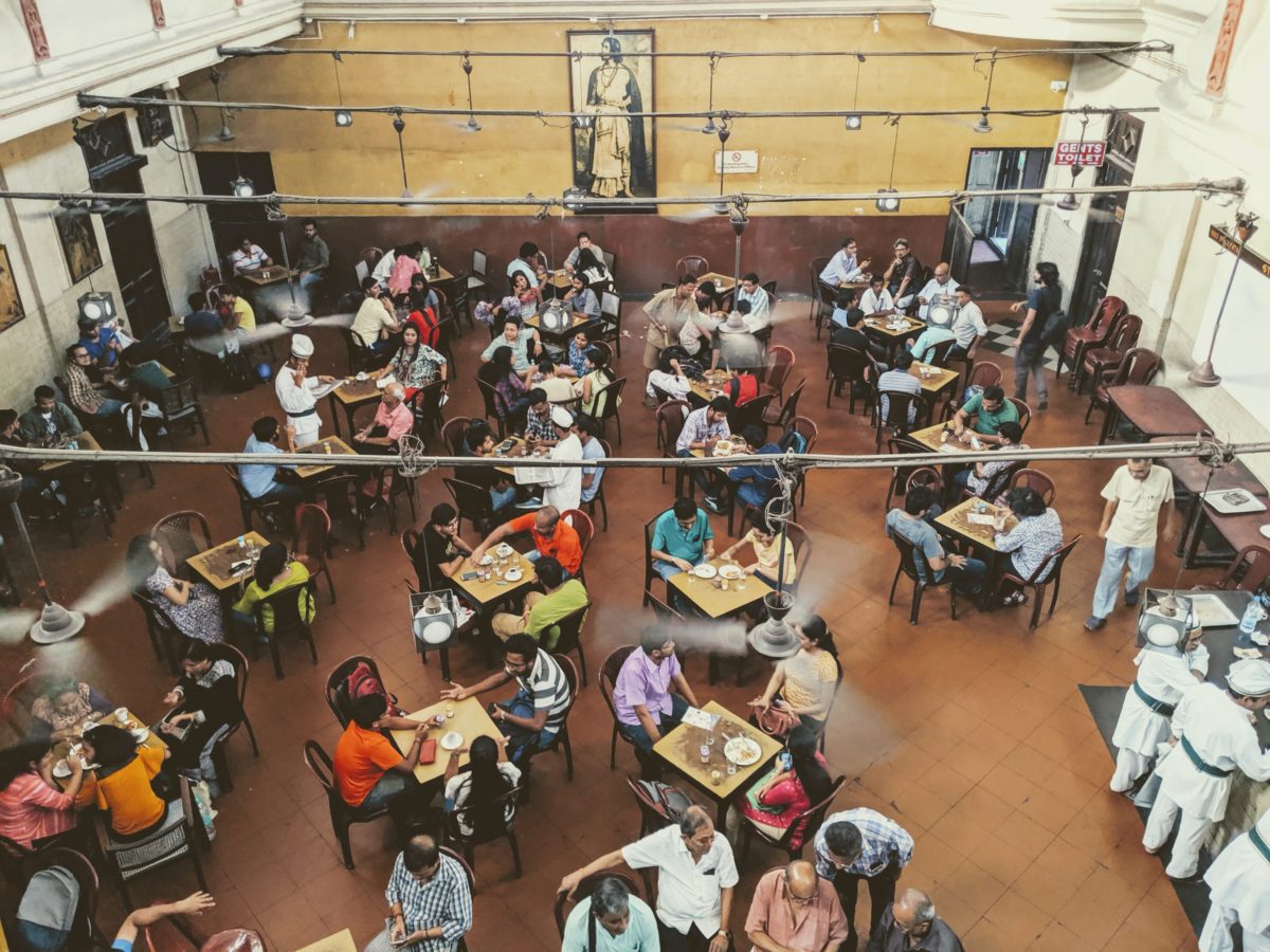 aerial view of patrons sitting at tables in a coffee house/restaurant in Kolkata, India.