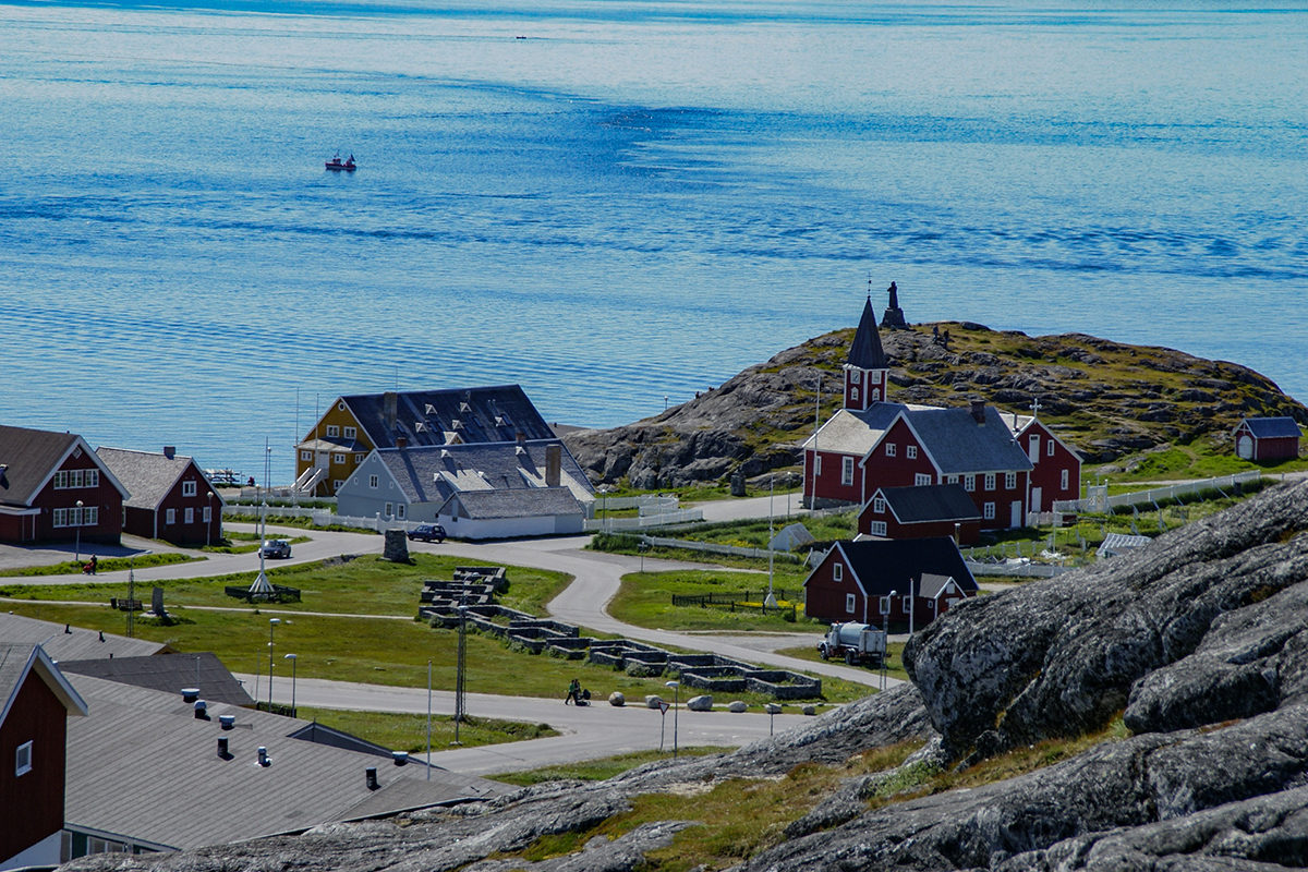 a road through an arctic town leading to the sea