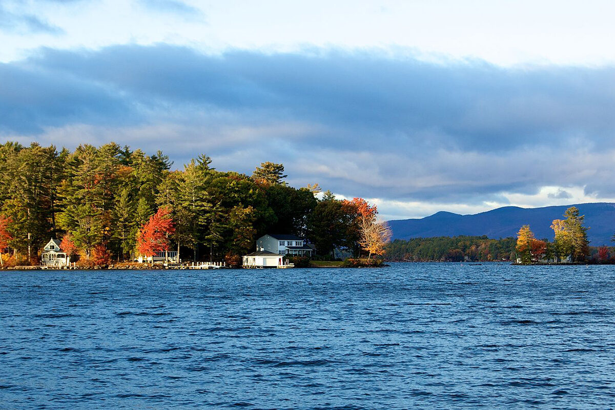 a house on a lake surrounded by trees