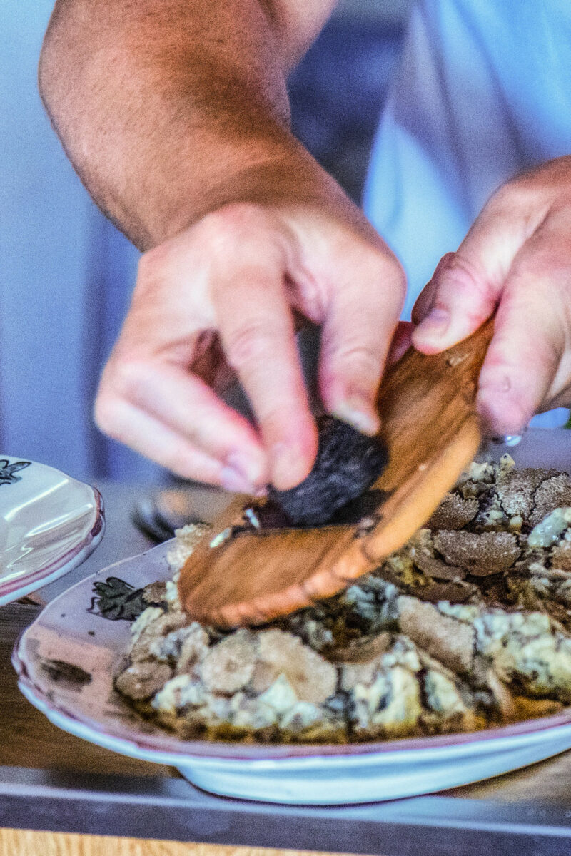 chef shaving truffles over a pasta dish