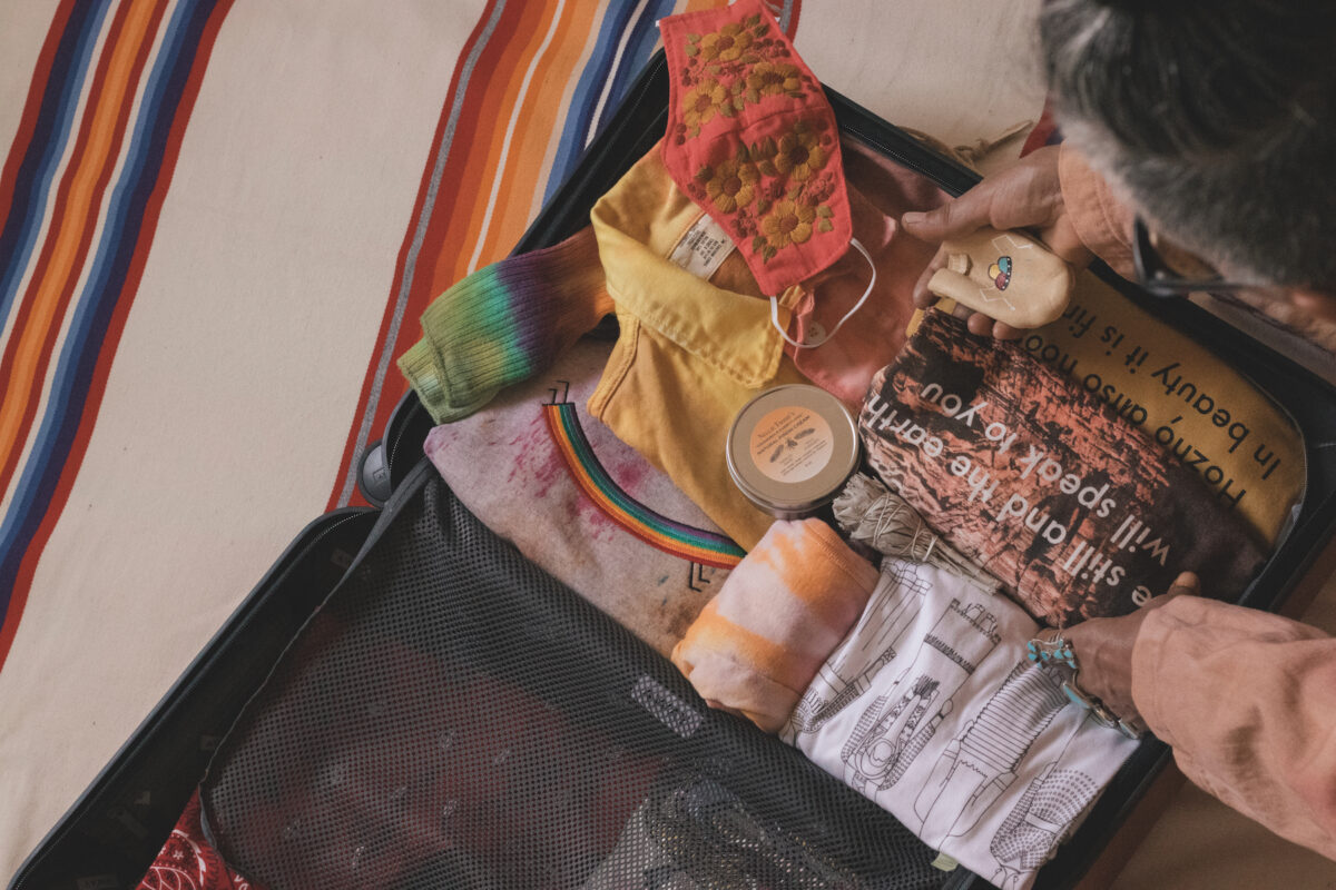 a suitcase packed with t shirts and jewelry