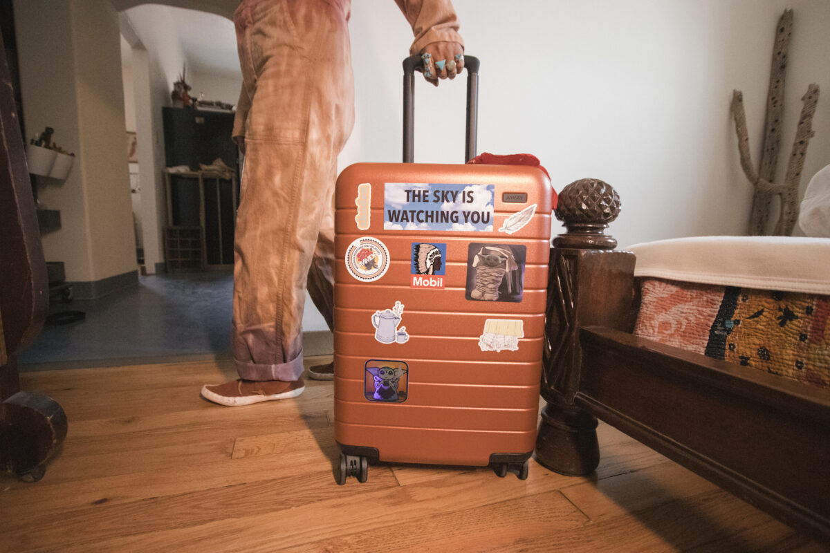 a suitcase covered in stickers