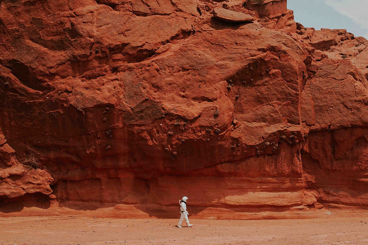 an astronaut walking in rocky landscape