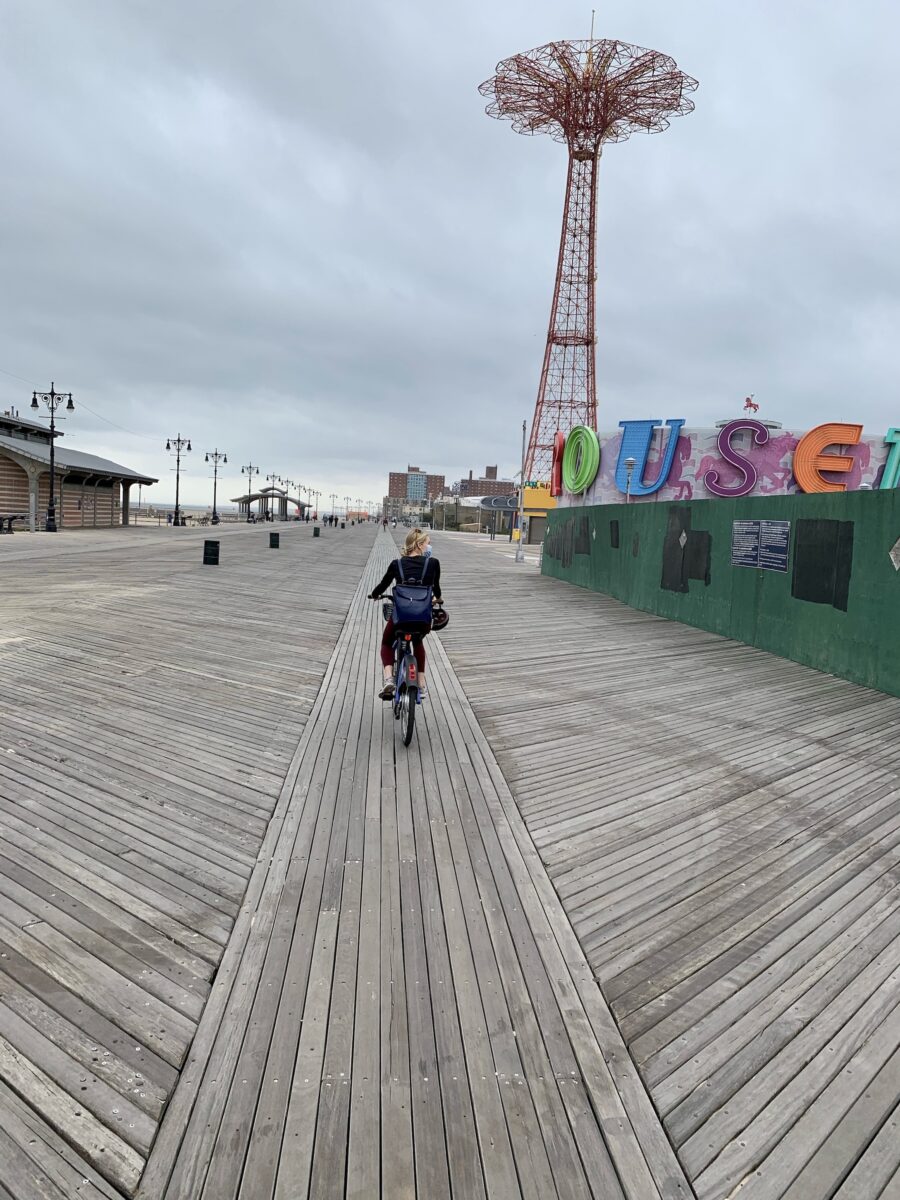 a person riding a bike down a boardwalk