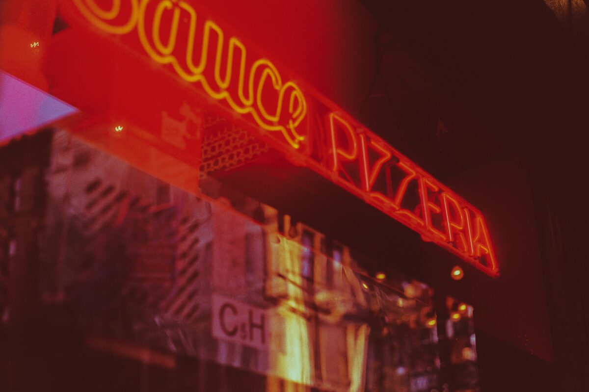 a neon red pizza restaurant sign