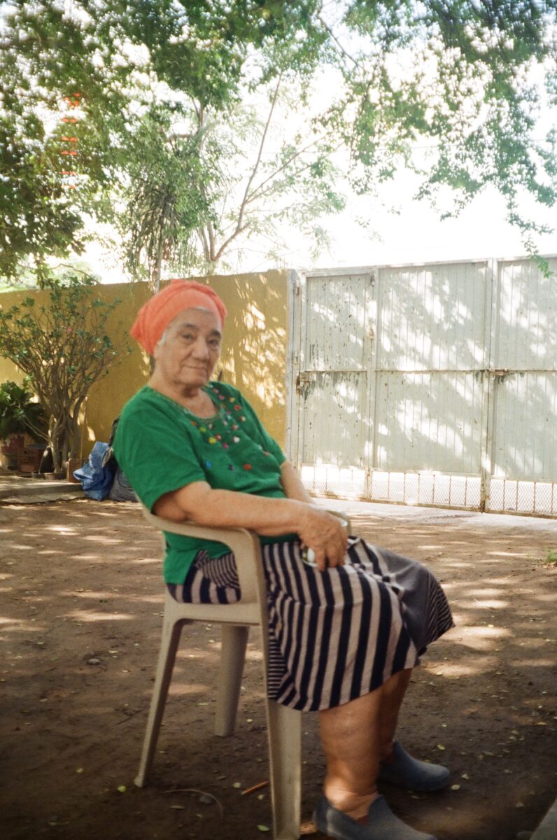 an elderly woman posing in a lawn chair